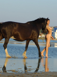 Hairy pussy busty naturist walking with a horse in the water